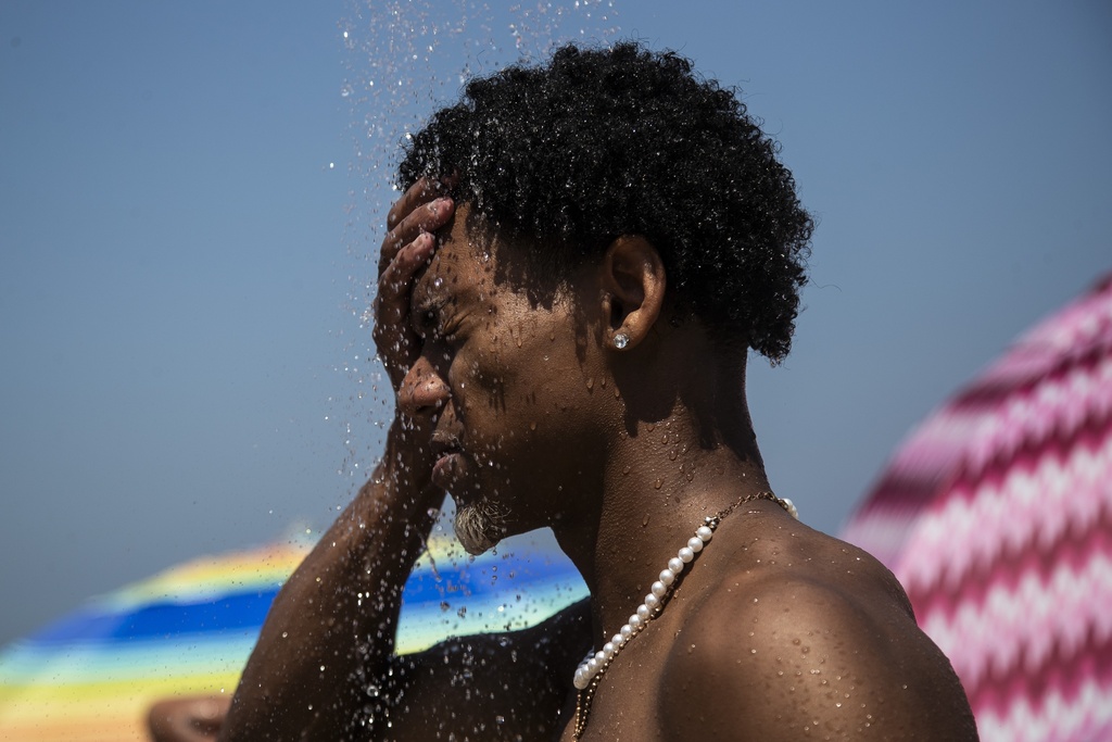 A man cools off in a shower at Ipanema beach, Rio de Janeiro, Brazil, Sept. 24, 2023. 