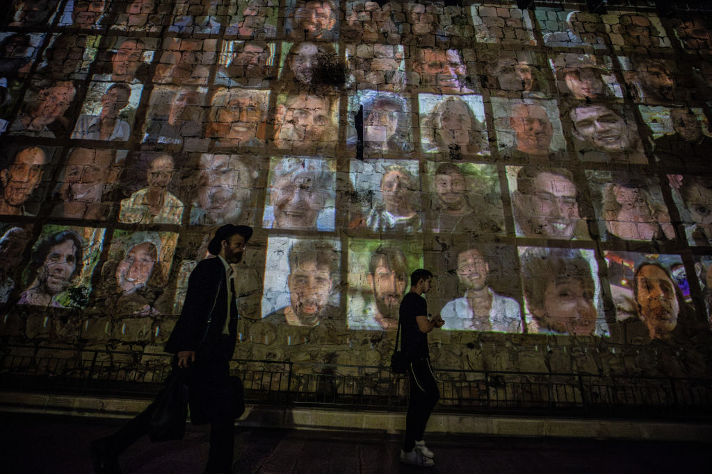 Photographs of Israelis taken hostage by Hamas are reflected on the walls of the Old City in Jerusalem 