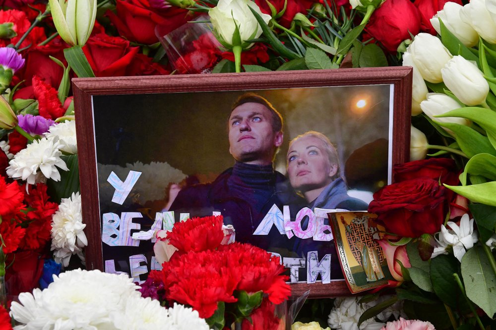 Mourners react as the hearse carrying the coffin of late Russian opposition leader Alexei Navalny leaves the Mother of God Quench My Sorrows church towards the Borisovo cemetery for Navalny's burial, in Moscow's district of Maryino on March 1, 2024.