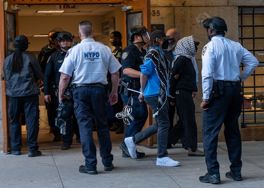 Pro-Palestinian protesters are escorted out of Columbia University's Butler Library after their arrest for occupying the library space in New York City on May 7, 2025.