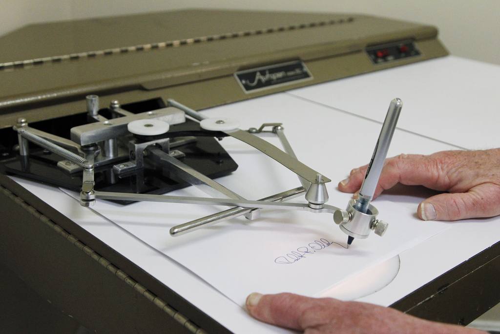 Bob Olding, president of Damilic Corp., the leading manufacture of automatic signing machines for replicating authentic signatures, demonstrates the features of the older model Autopen Model 80 in Rockville, Md., on June 13, 2011.
