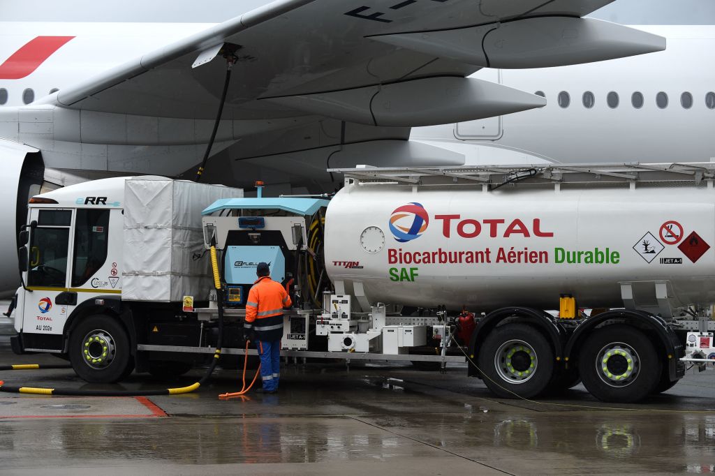 Staff members refuel an Airbus A350-900, the first Air France jet long-haul aircraft fuelled with sustainable aviation fuel produced by French energy group Total at Roissy airport on May 18, 2021. 