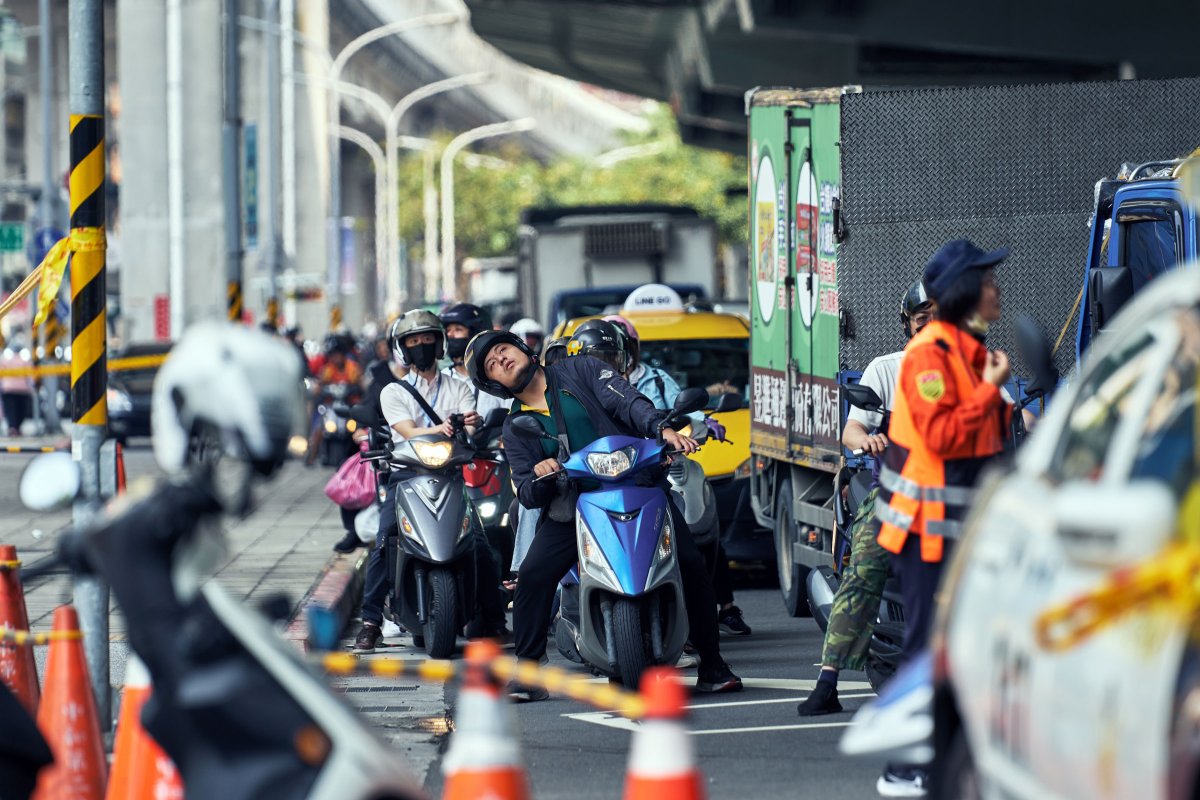 一名驾驶员在台湾台北市地震后抬头看着台北捷运的高架轨道受损