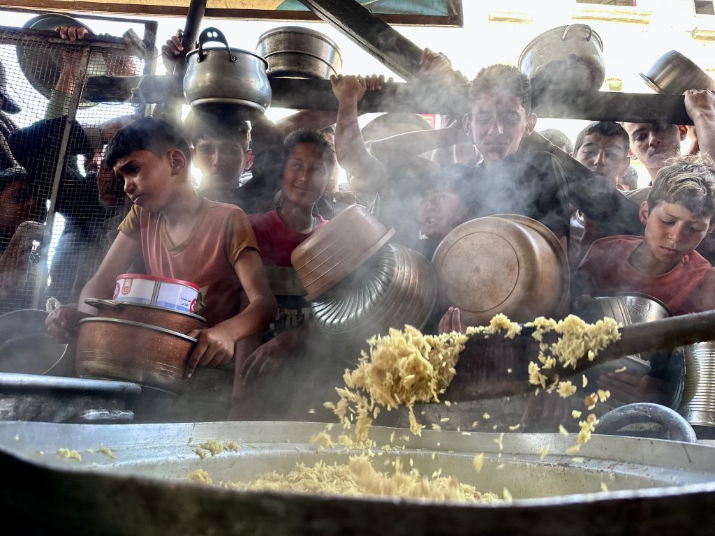 Palestinian children in Gaza queue for a hot meal