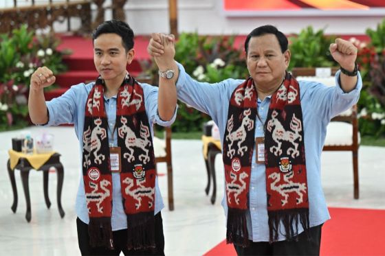 Presidential candidate Prabowo Subianto (R) and vice presidential candidate Gibran Rakabuming Raka (L), son of Indonesia's President Joko Widodo, pose for photographs during the registration for the 2024 election in Jakarta on Oct. 25, 2023.