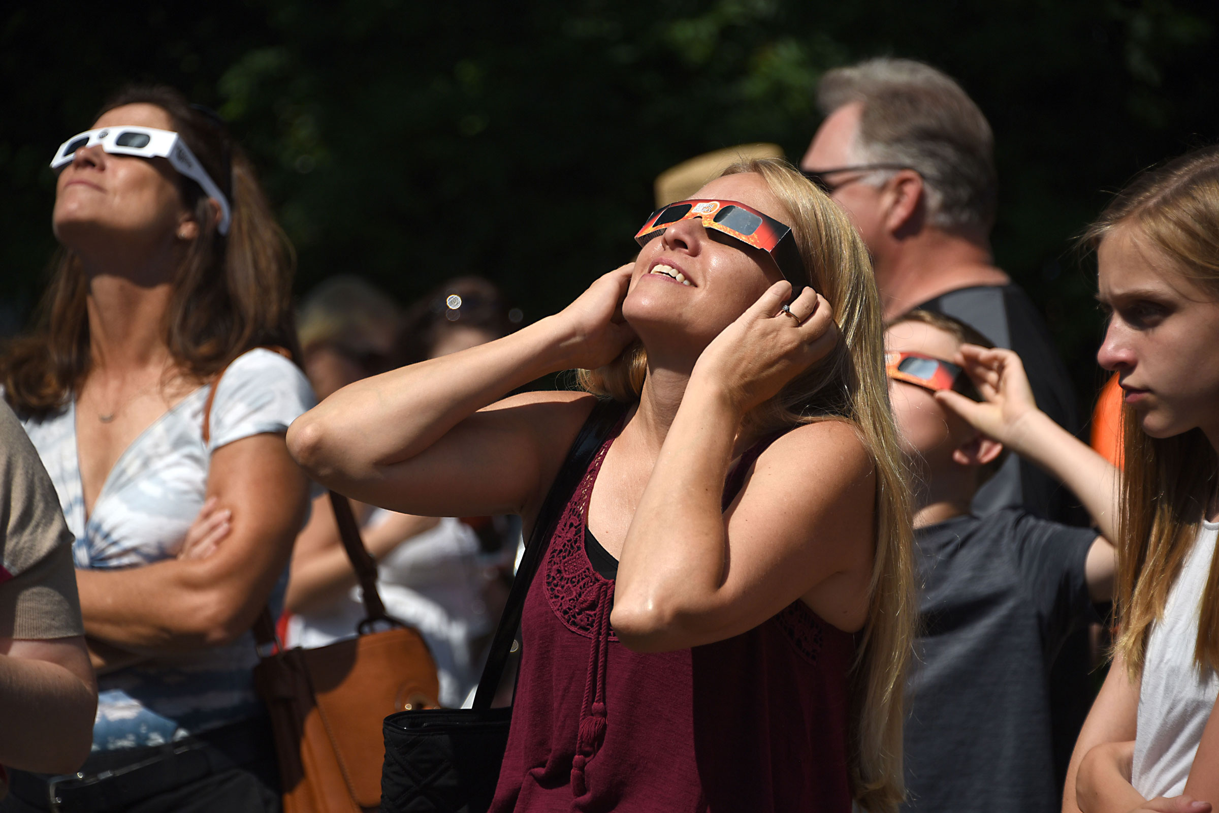 2017 年 8 月 21 日，人们在纽约斯内克塔迪用特殊的日食眼镜观看日食。
