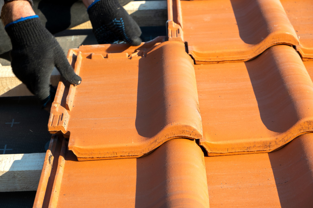 closeup worker hands installing yellow ceramic roofing tiles mounted wooden boards covering resident