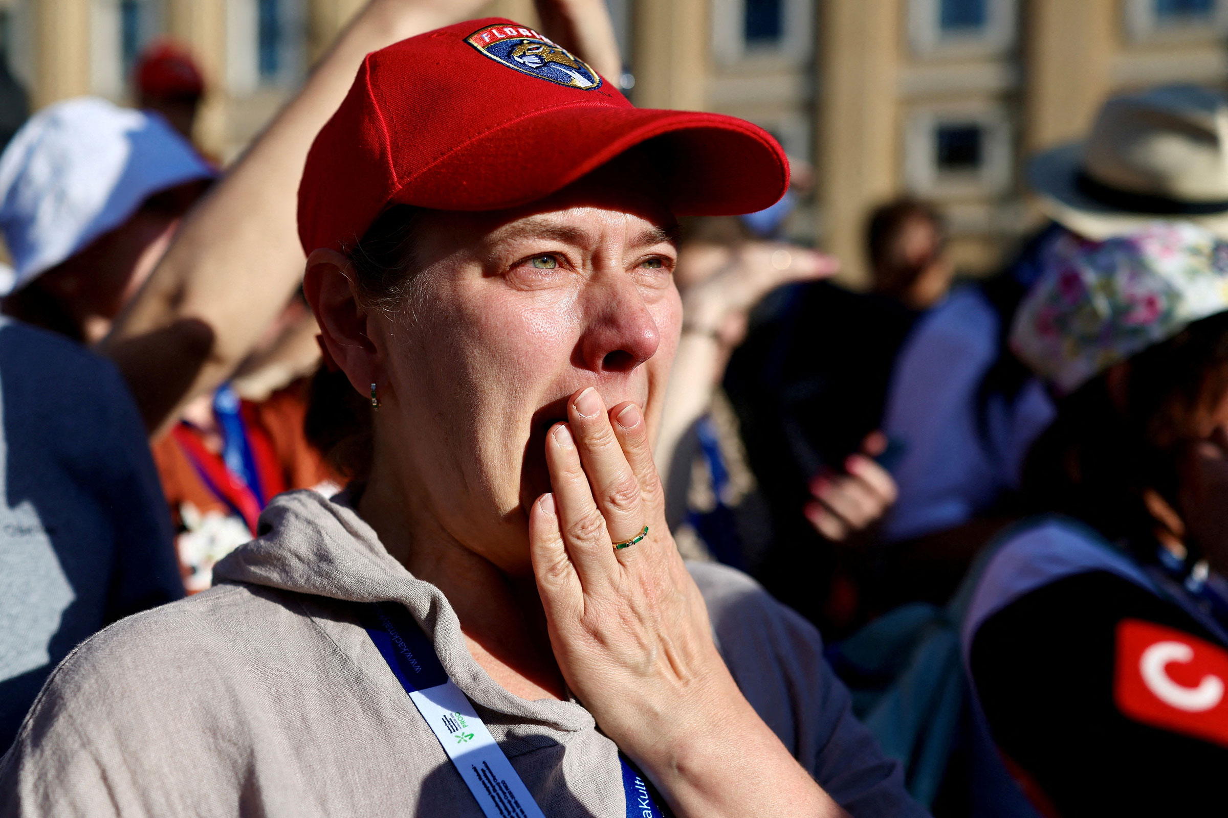 People react as white smoke rises from the chimney on the Sistine Chapel, indicating that a new pope has been elected at the Vatican, as seen from Rome, Italy, May 8, 2025.
