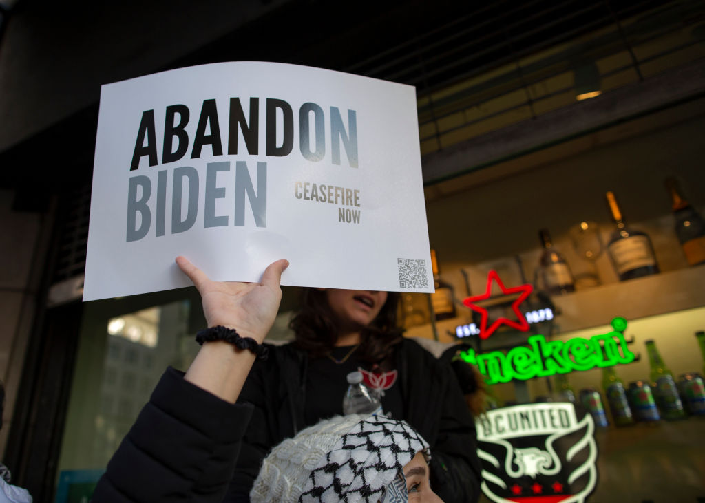 A demonstrator holding a sign with the text reading 