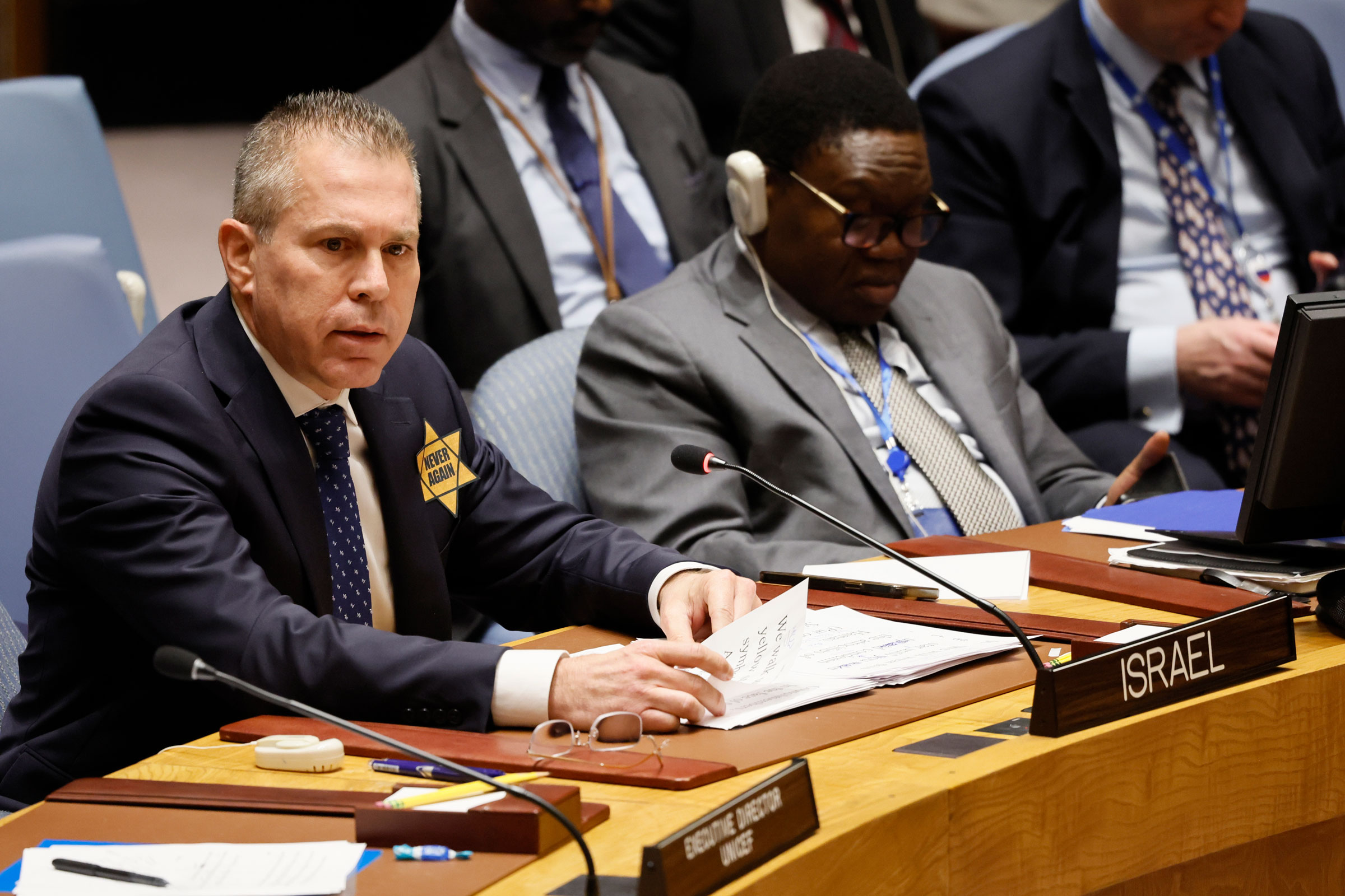 Israeli United Nations Ambassador Gilad Erdan, wearing a yellow star with the words “Never Again,” speaks during a Security Council meeting on the Israel-Hamas war at U.N. headquarters