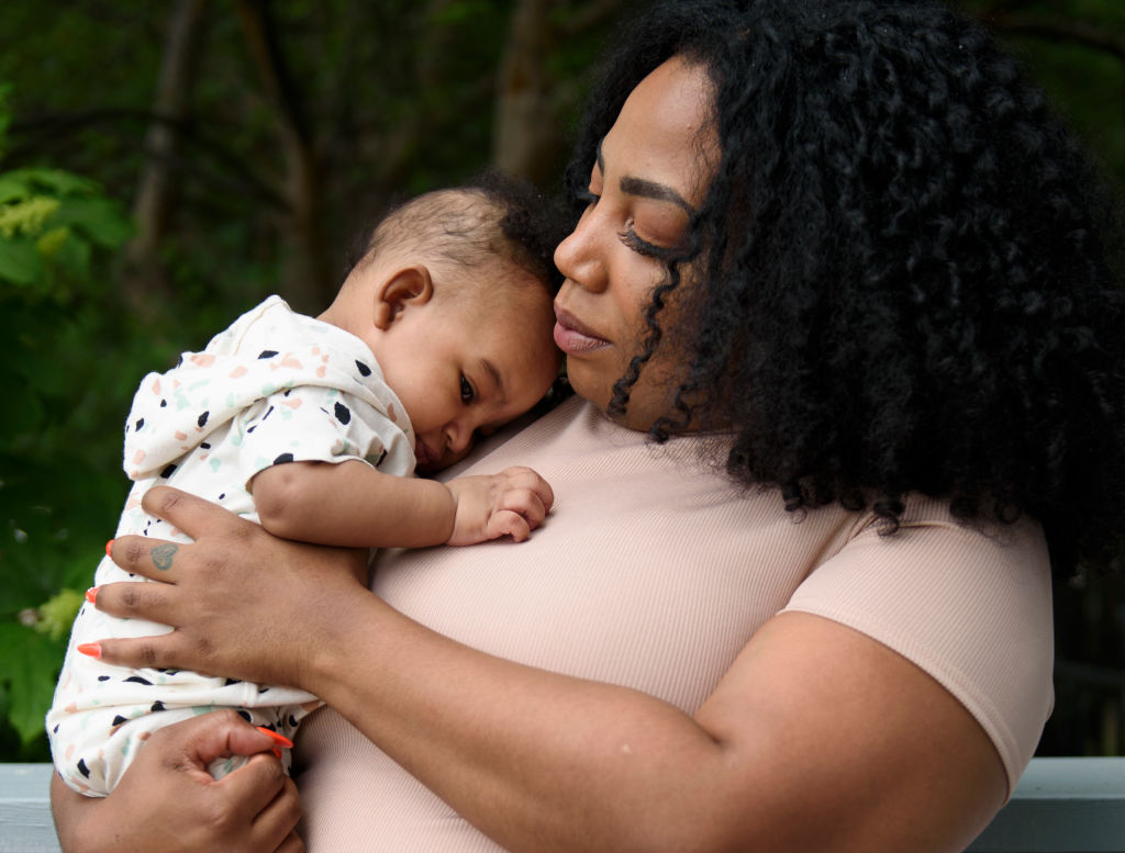 A woman poses with her infant.