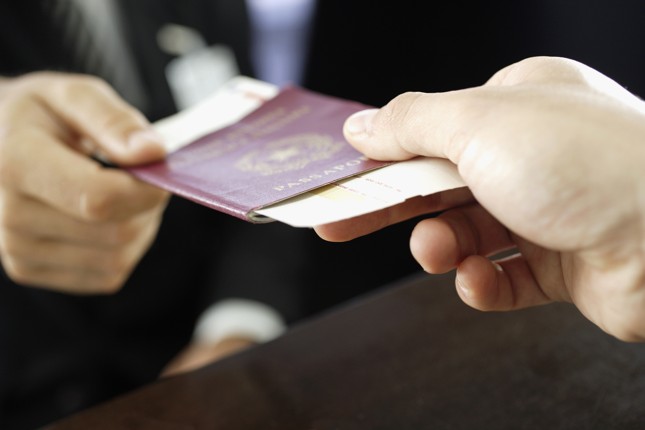 Traveler Handing Passport to Ticket Agent