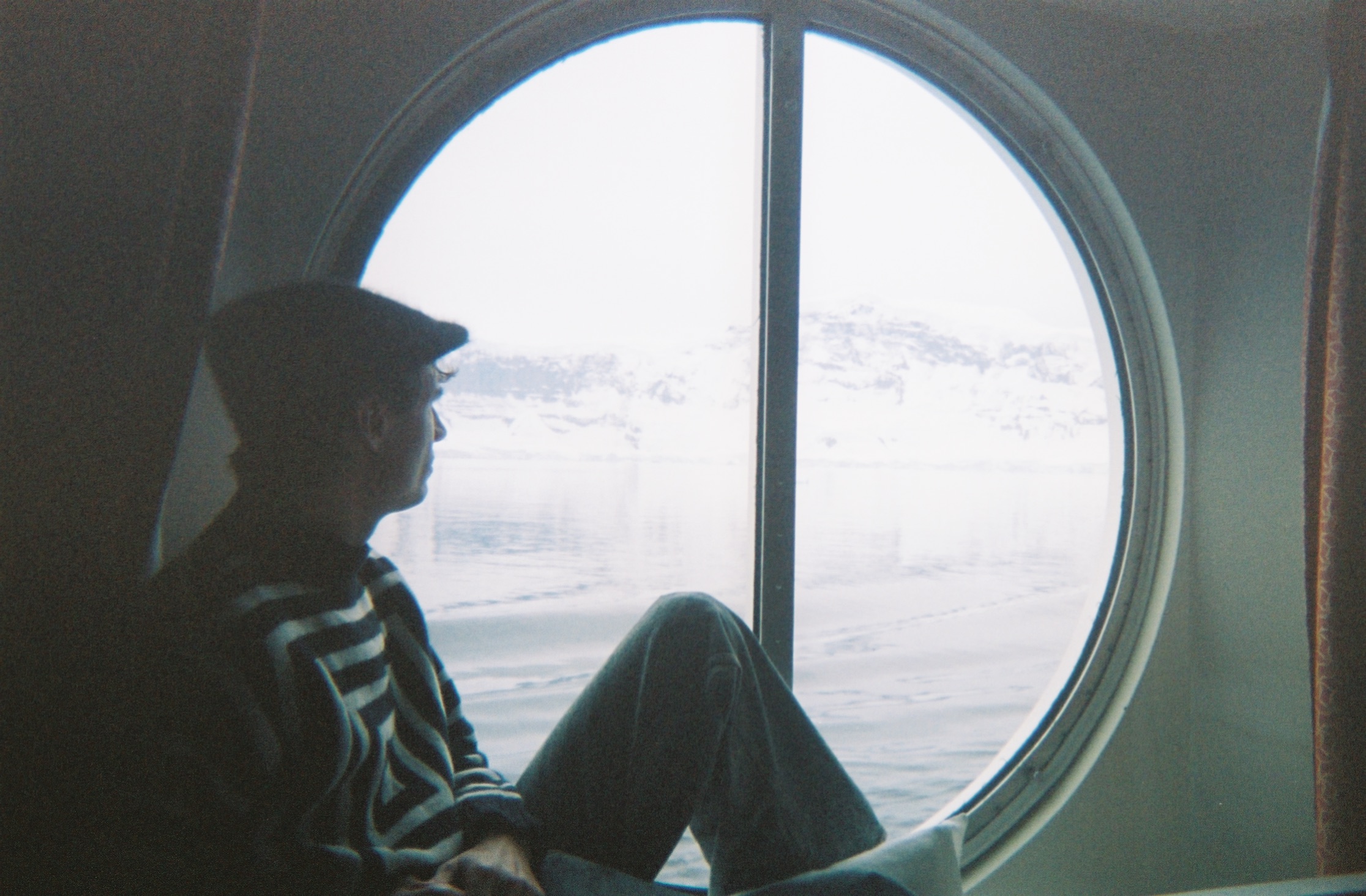 Marc looking out a window on a cruise