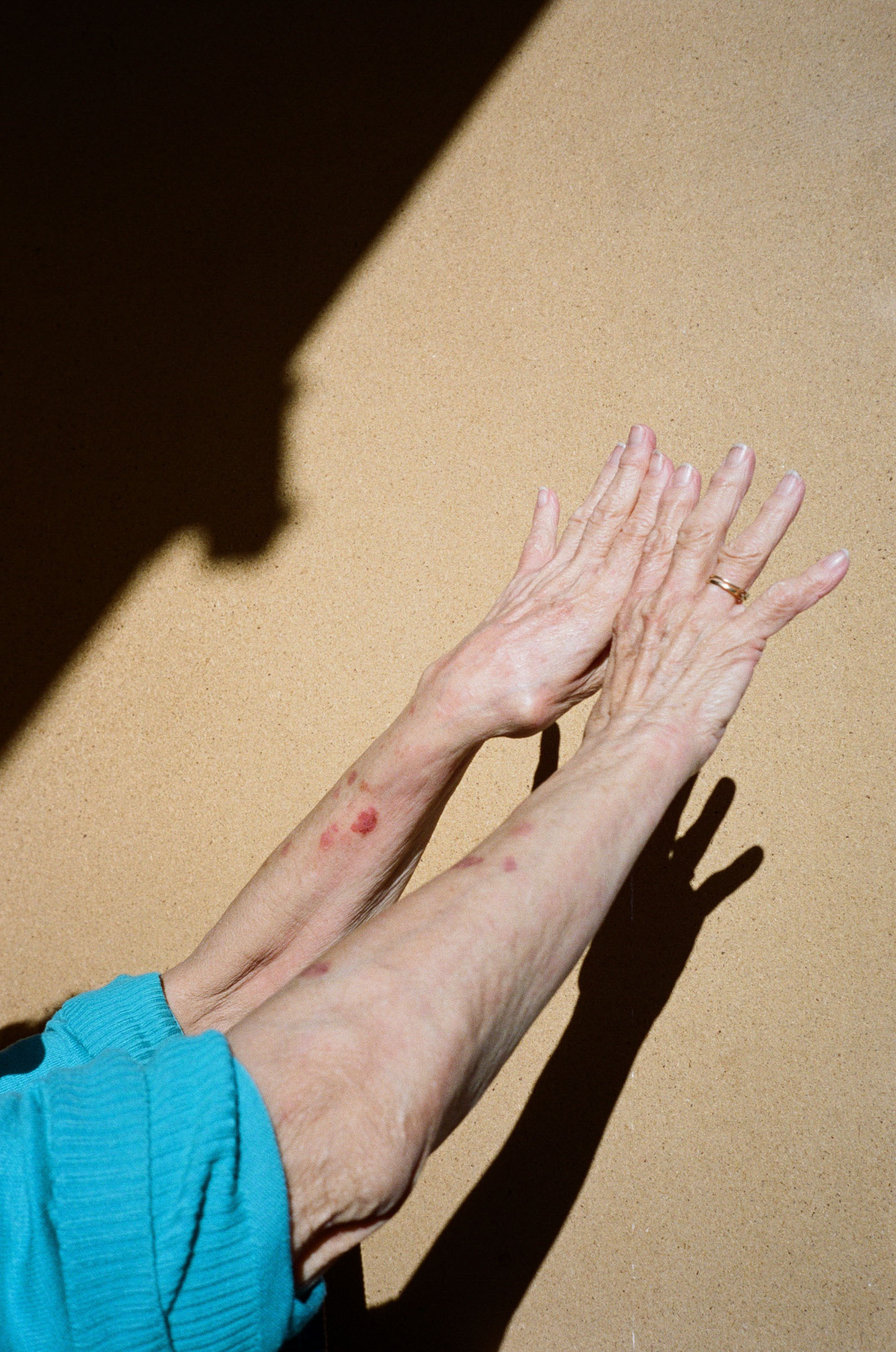 Older hands reaching into the sunlight