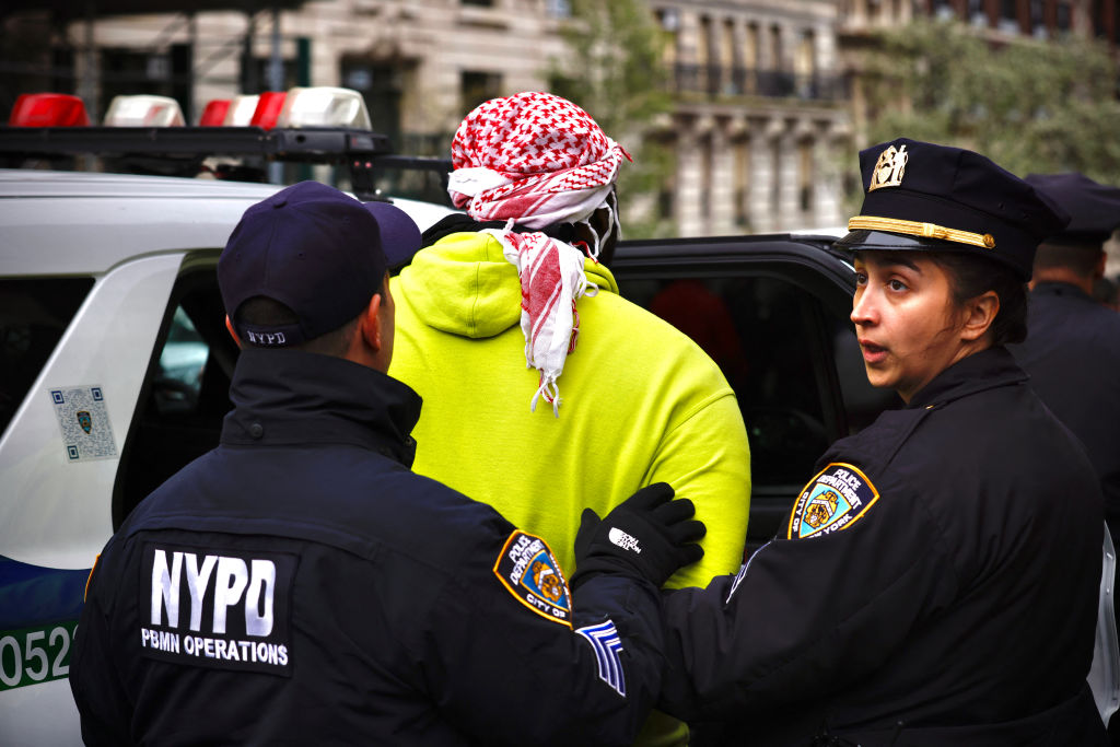 NYPD officers detain a person as pro-Palestinian protesters gather outside of Columbia University in New York City on April 18, 2024. 