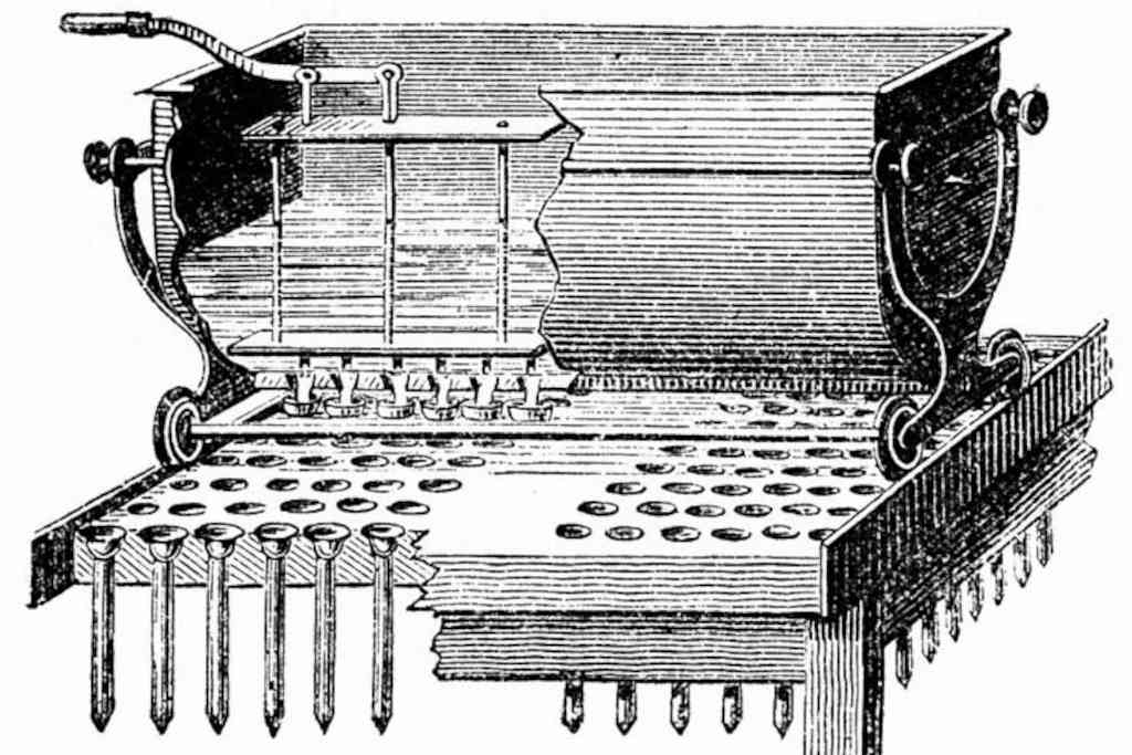 Machine muni d’un réservoir de suif fondu roulant au-dessus de moules en étain disposés sur plusieurs lignes dans des trous qui servent de support sur une planche de bois