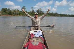 Andrew Johnson on the Sepik River in Papua New Guinea. He is wearing a Visor® Buff® and raising his arms in a victory pose. Image taken during the first source to sea traverse of the Sepik River in Papua New Guinea. © Clark Carter. http://www.adventureplaybook.com/