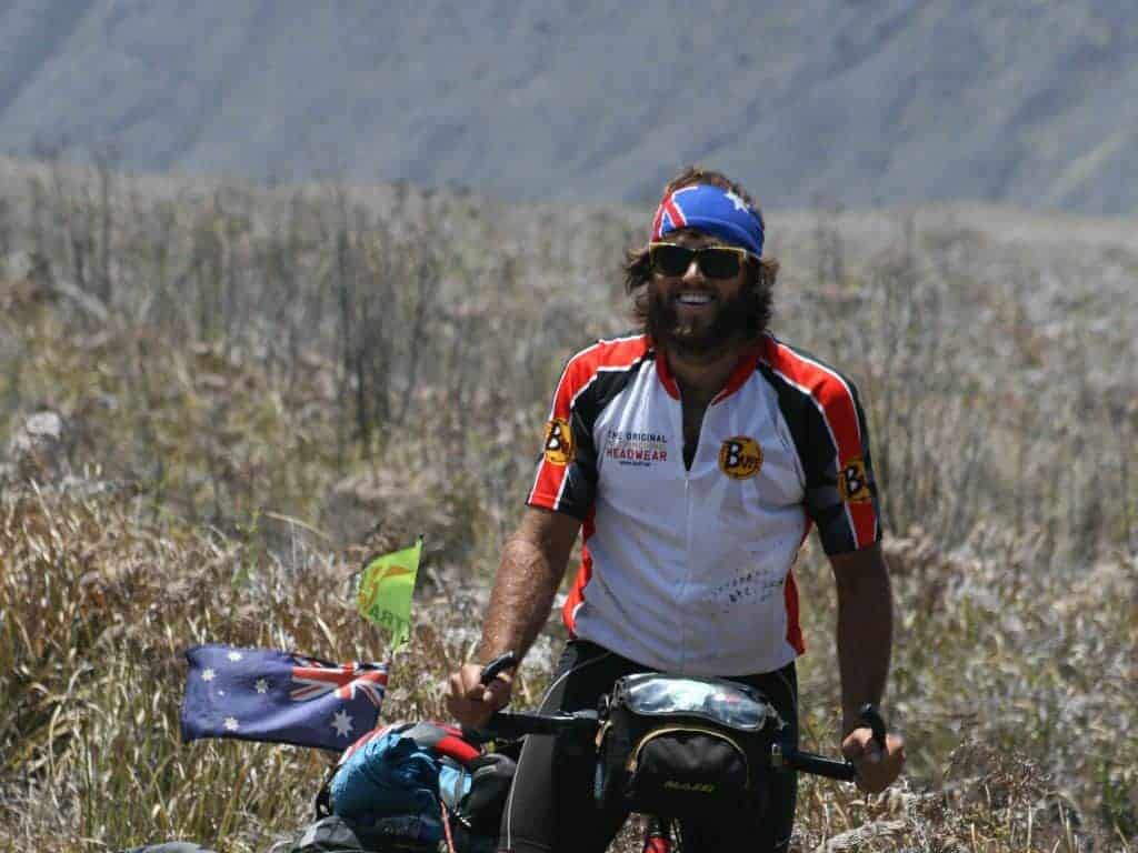 Rian Cope cycling up the highlands in Indonesia. Rian is wearing Buff® team wear and a Australia Flag Original Buff®. It's obvious that non of the fabrics are wet or clingy. © EatSleepSurf.com.au