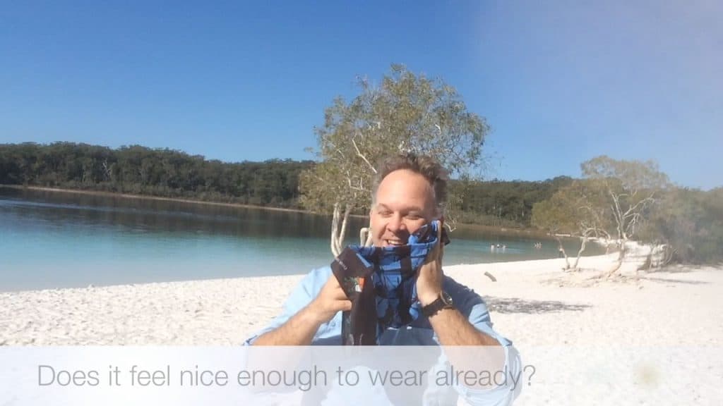 Edward holding the Original Buff® to his left cheek. He is smiling as he is enjoying a mild cooling effect.