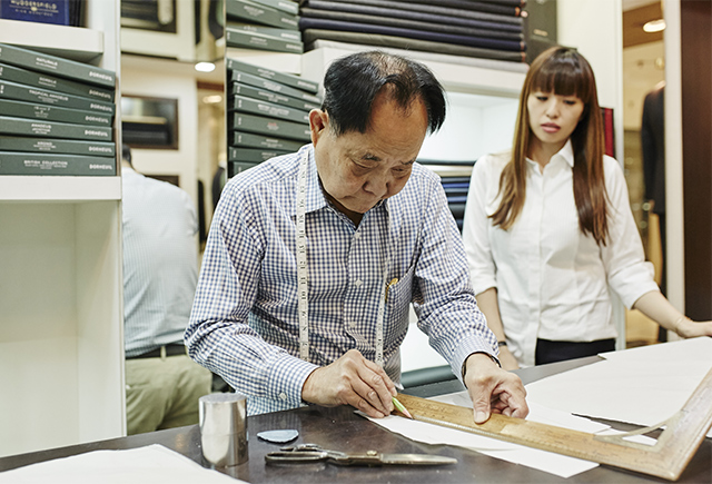 Wong measuring and cutting patterns for Cai Mei's jacket.