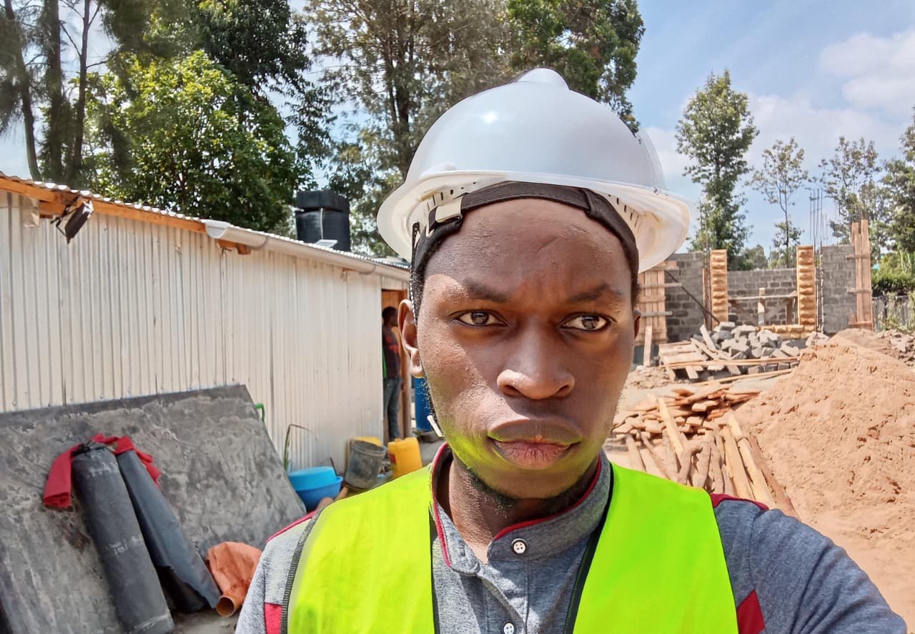 El-Bethel Buyanzi wearing a hard hat and reflective vest at a construction site