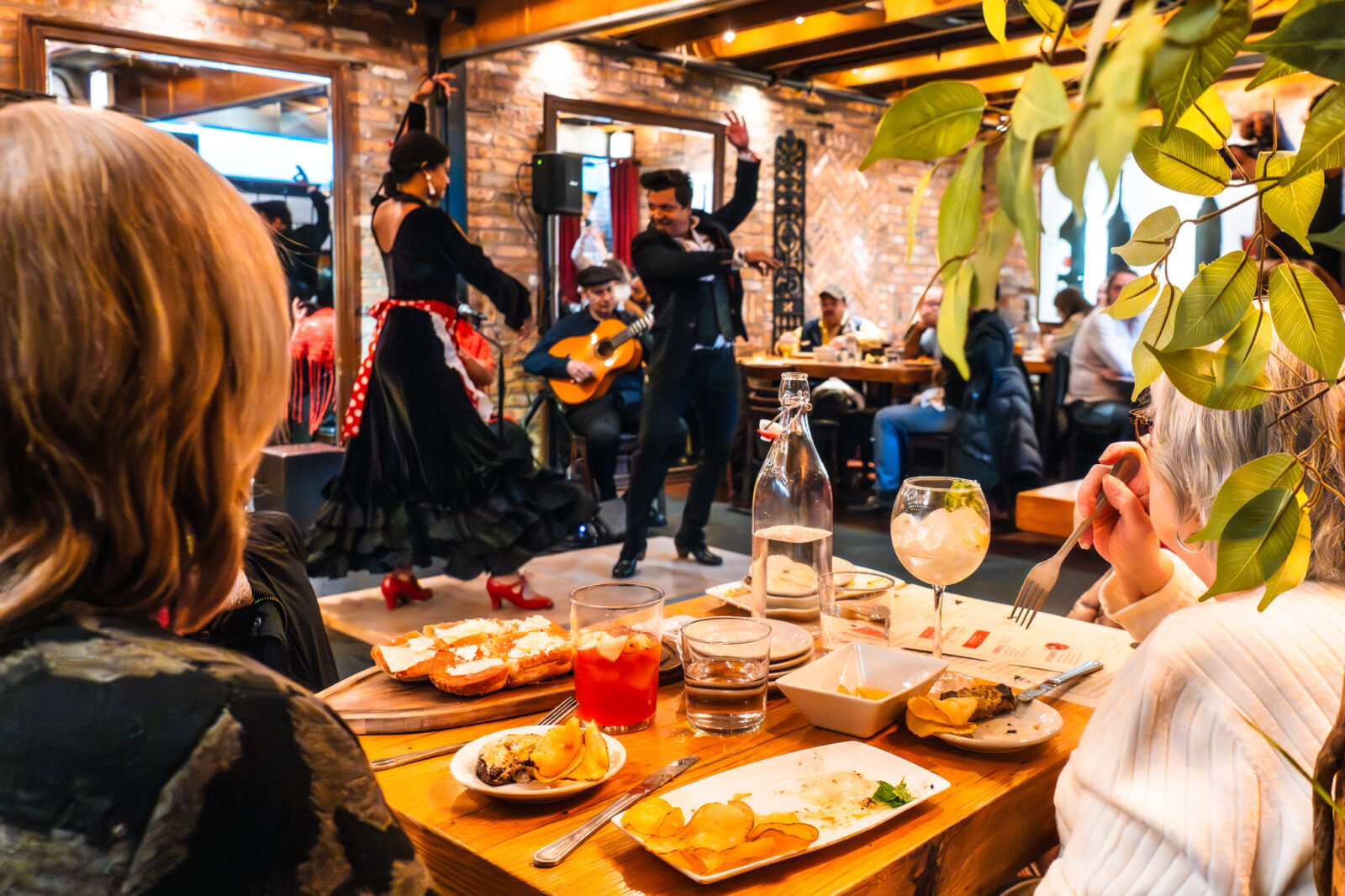 Two people experiencing the Friday Lunch Flamenco Shows as two flamenco dancers perform in front of them.