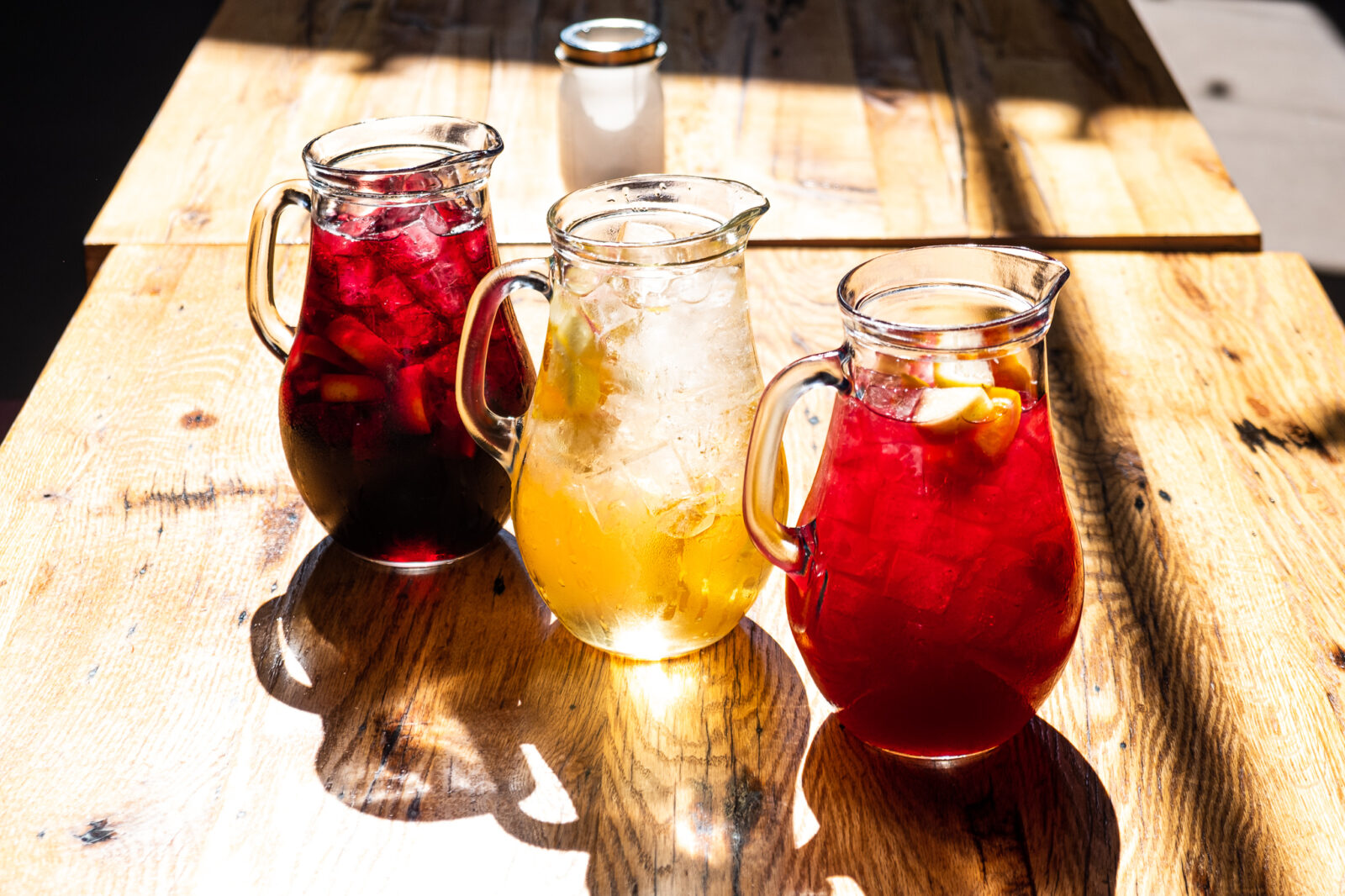Three pitchers of sangria at a Cafe Ba-Ba-Reeba! dining table used as a decorative photo for Breast Cancer Awareness Month