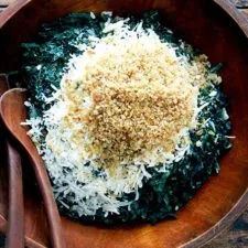 Ensalada de col rizada favorita con Parmigiano Reggiano, vinagreta de chalota y picatostes tostados