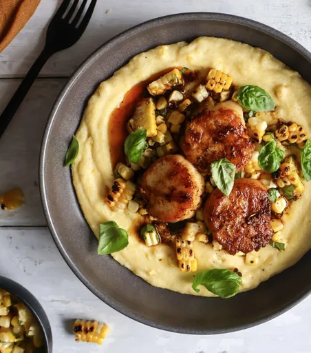 Vieiras sobre polenta cremosa de maíz dulce asado