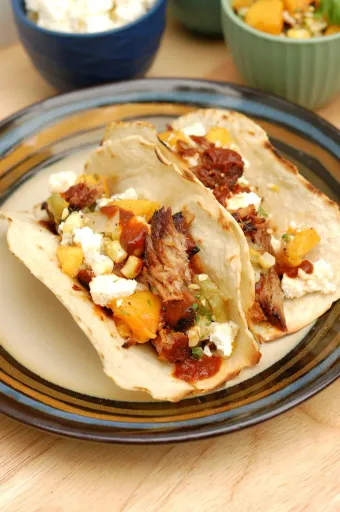 Tacos de cerdo desmenuzado con salsa de melocotón a la parrilla