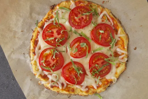 Pizza de base de coliflor con tomate y albahaca