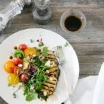 Ensalada de berenjena con tomates antiguos y rúcula