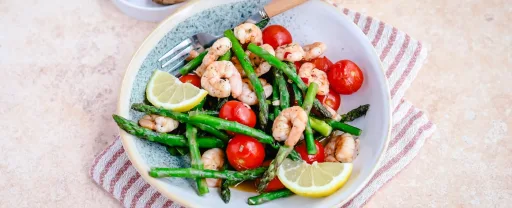 Gambas con espárragos verdes y tomates cherry