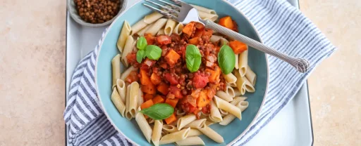 Penne con boniato y lentejas en salsa de tomate