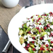 Ensalada tibia de coles de Bruselas con granada y queso de cabra