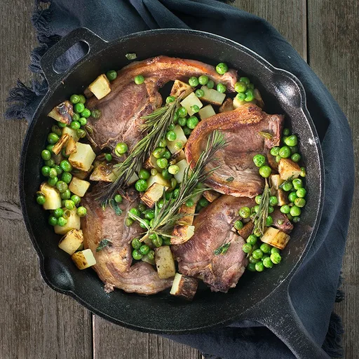 Chuletas de cordero en una sola sartén con patatas crujientes y guisantes a la menta