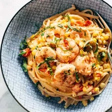 Pasta cremosa con gambas, maíz y tomates
