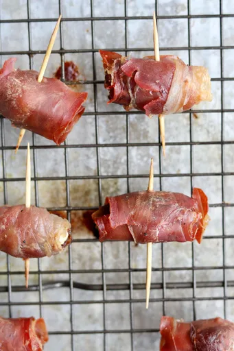 Dátiles rellenos envueltos en jamón serrano