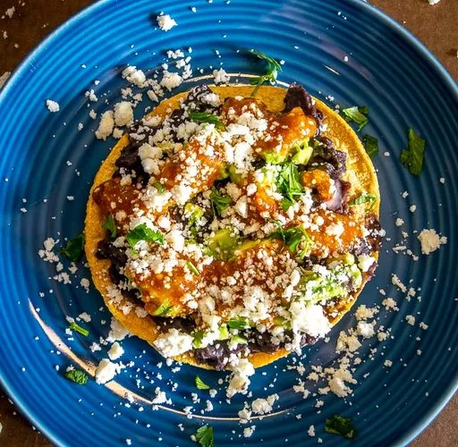 Tostadas de alubias con aguacate, queso fresco y salsa casera
