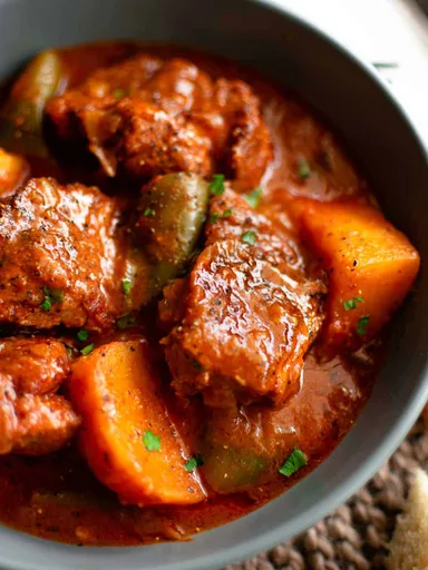 Cerdo en salsa de tomate con patatas y pimientos
