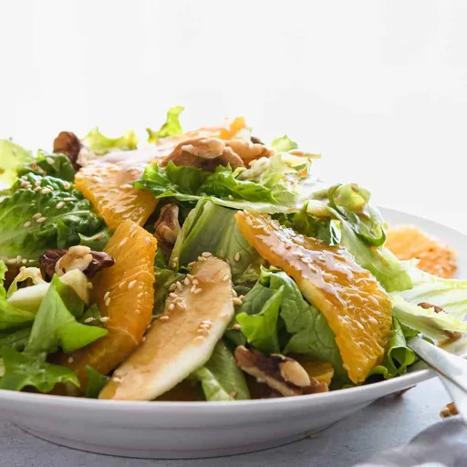 Ensalada de lechuga y naranja con nueces y sésamo
