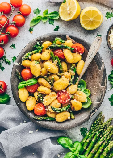 Ñoquis cremosos con espárragos y tomates