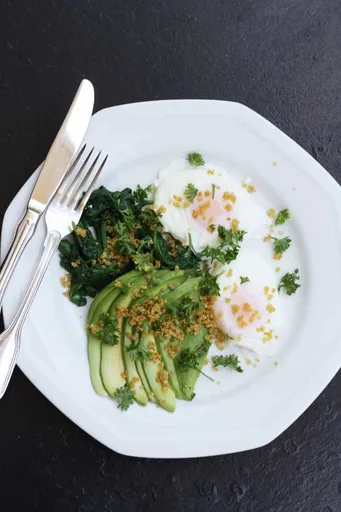 Huevos escalfados con aguacate, espinacas y quinoa crujiente