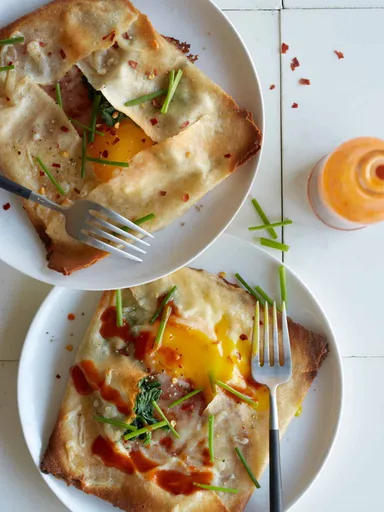 Crepes de desayuno rellenos de jamón, espinacas y queso suizo