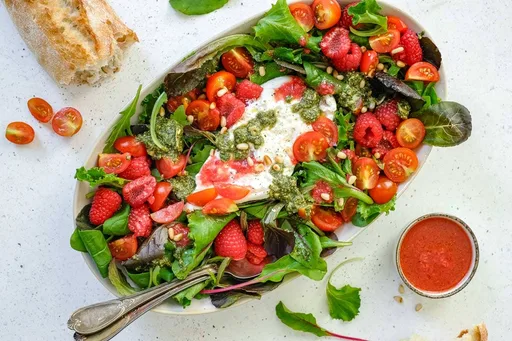 Ensalada de burrata con tomate, frambuesa y pesto