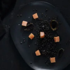 Salmón mi-cuit con lentejas Beluga negras