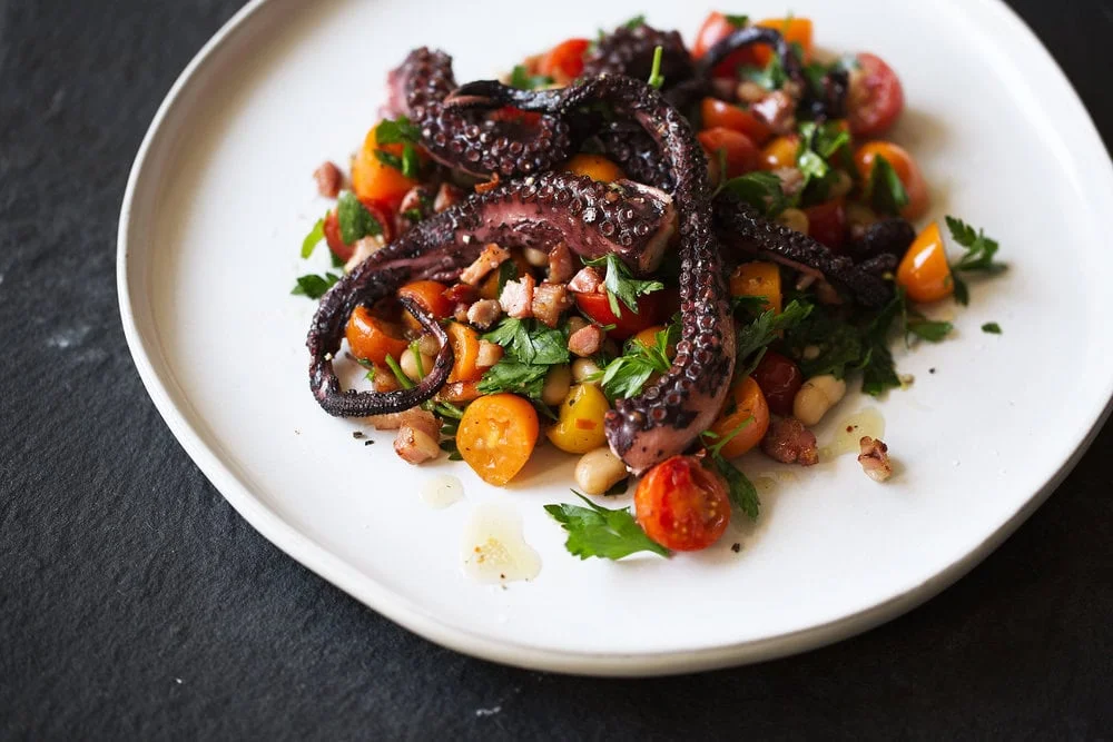 Charred Octopus with Warm White Bean and Tomato Salad and Guanciale Vinaigrette