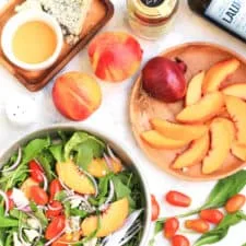 Ensalada de melocotón, rúcula y tomate con aderezo de miel y aceite de oliva