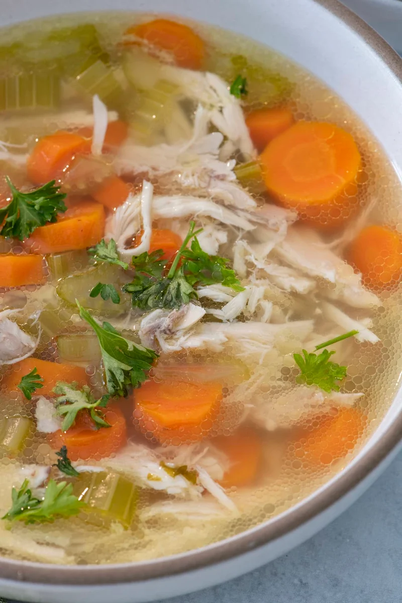 Sopa de pollo en olla a presión con pollo entero