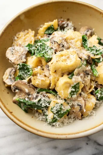 Tortellini cremosos con espinacas y champiñones